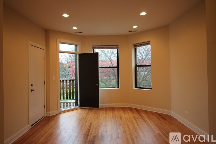 A room with wooden floors and a black door.