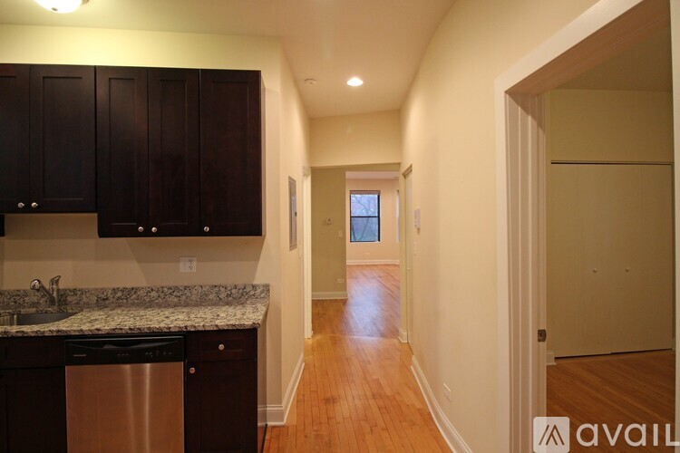 A kitchen with dark brown cabinets and a granite countertop.