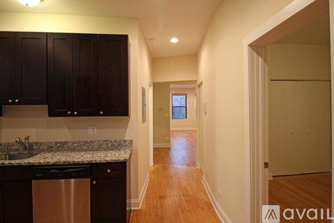 A kitchen with dark brown cabinets and a granite countertop.