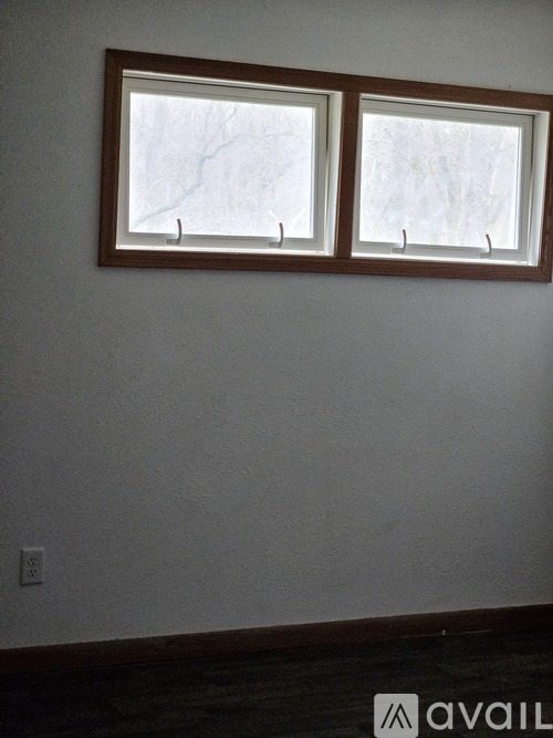 Two windows in a room with white walls.