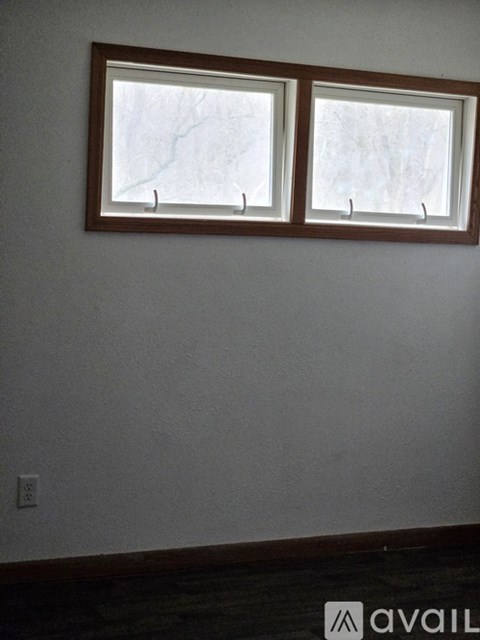 Two windows in a room with white walls.