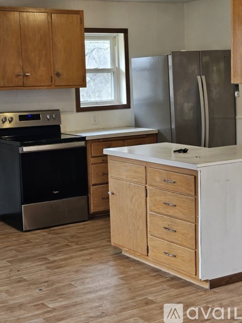 A kitchen with wooden cabinets and a black stove top oven.