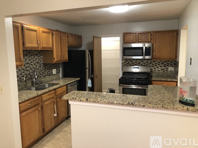 A kitchen with granite countertops and wooden cabinets.