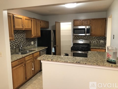 A kitchen with granite countertops and wooden cabinets.