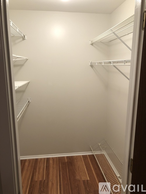 Empty white shelves in a room with wood flooring.