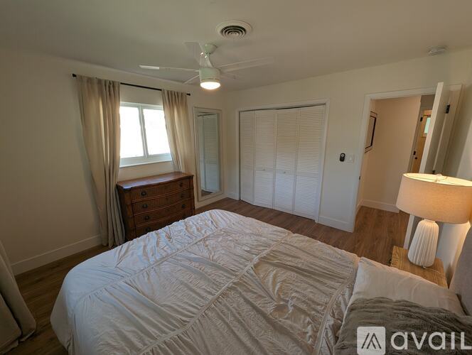 A bedroom with a large bed and a ceiling fan.