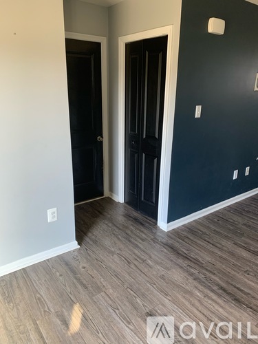 A hallway with two doors and a wooden floor.