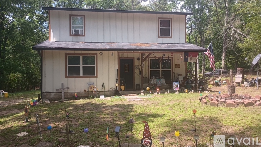 A white house with a porch and a flag on it.