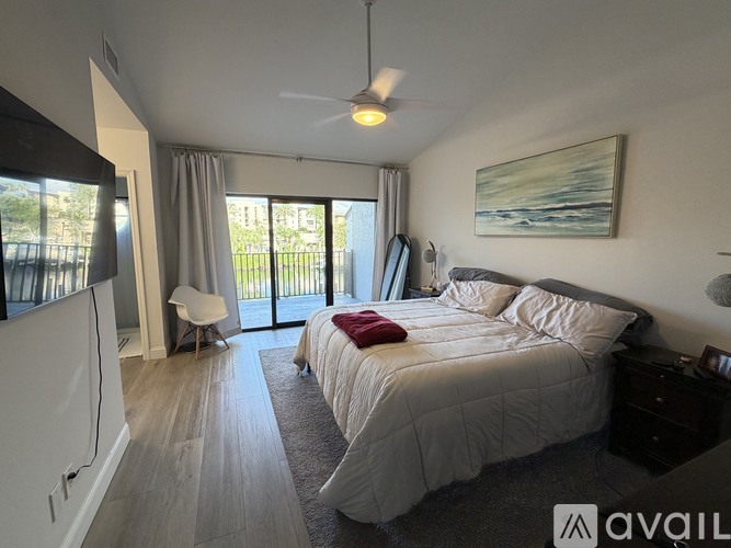 A bedroom with a large bed and a ceiling fan.