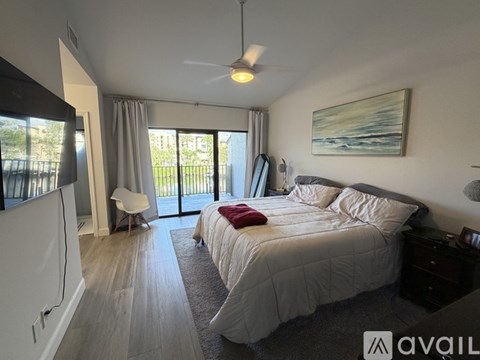 A bedroom with a large bed and a ceiling fan.