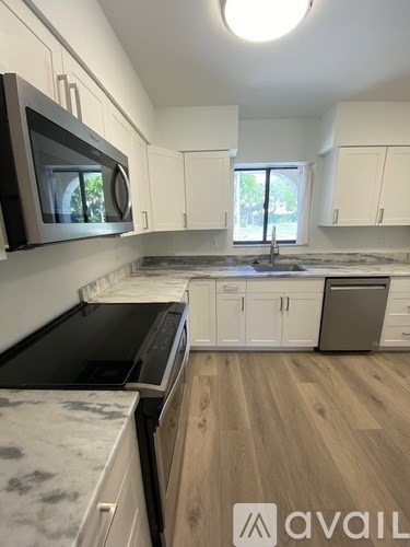 A kitchen with a black microwave above a stove top oven.