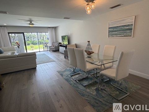 A spacious room with wooden flooring and a ceiling fan.