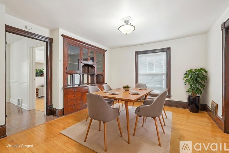 A dining room with a wooden table and chairs.