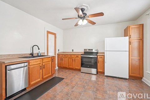 A kitchen with wooden cabinets and a tile floor.
