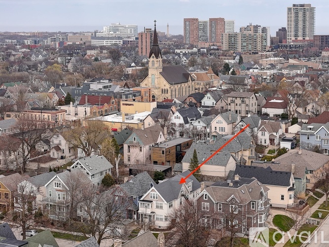 A cityscape with a church and tall buildings in the background.