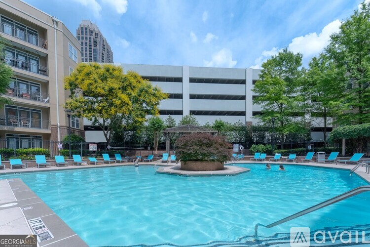 A large swimming pool surrounded by lounge chairs and trees.