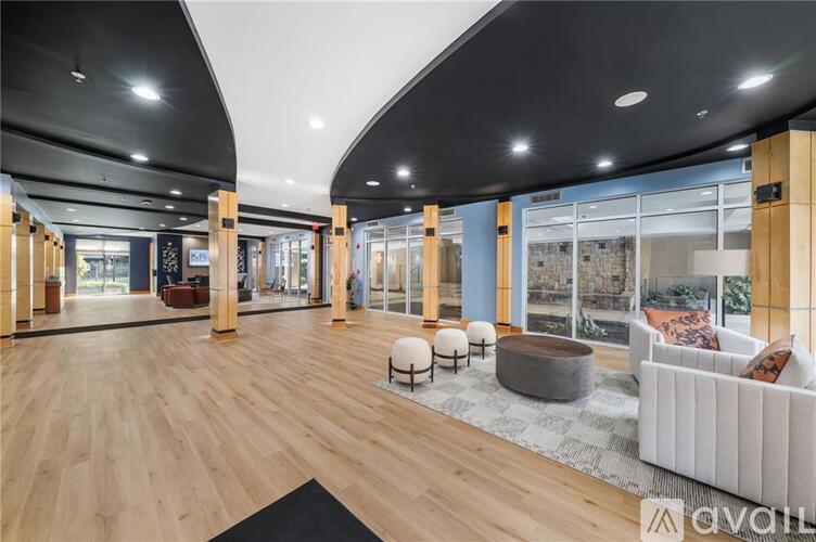 A spacious living room with wooden floors and a large window.