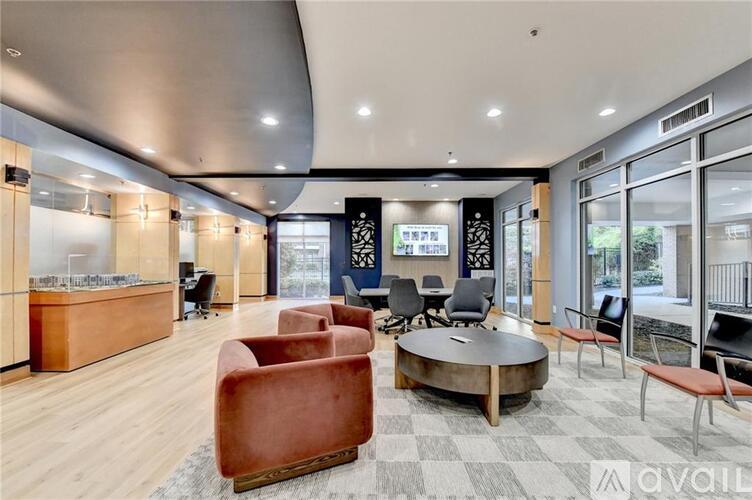 A modern office space with a curved ceiling, wooden floors, and a variety of seating options.