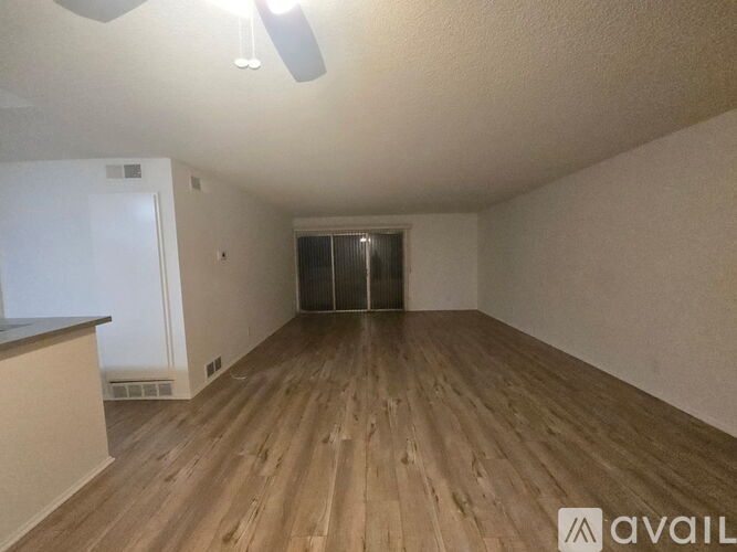 A room with wooden flooring and a ceiling fan.