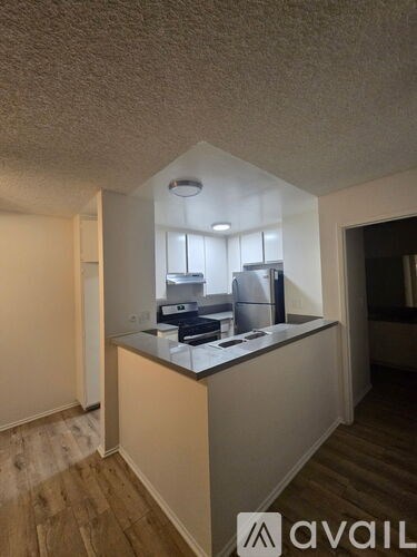 A kitchen area with a counter and a refrigerator.