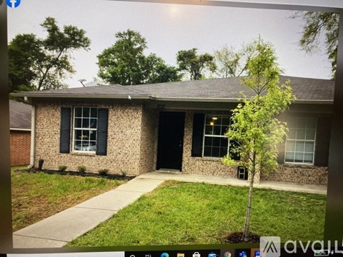 A house with a brown brick exterior and a black door.