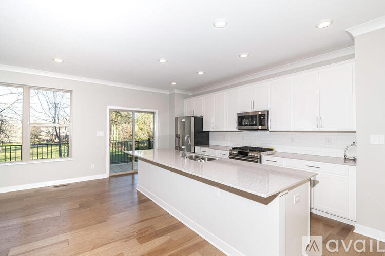 A kitchen with white cabinets and a wooden floor.