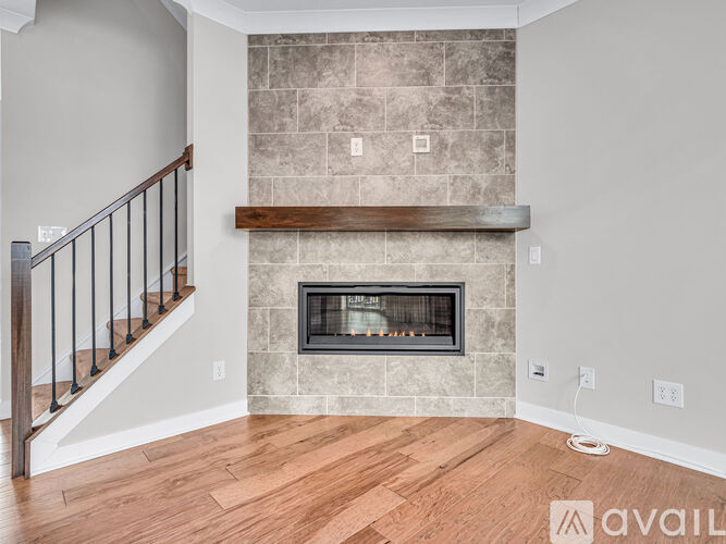 A living room with a fireplace and wooden floors.