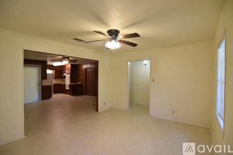 A spacious room with a ceiling fan and tiled flooring.