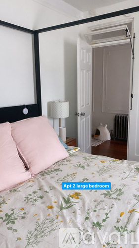 A bedroom with a large bed and a doorway leading to another room.