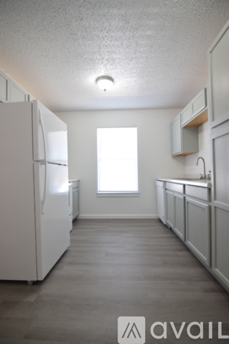 A kitchen with white appliances and cabinets.