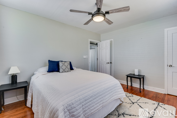 A bedroom with a large bed and a ceiling fan.