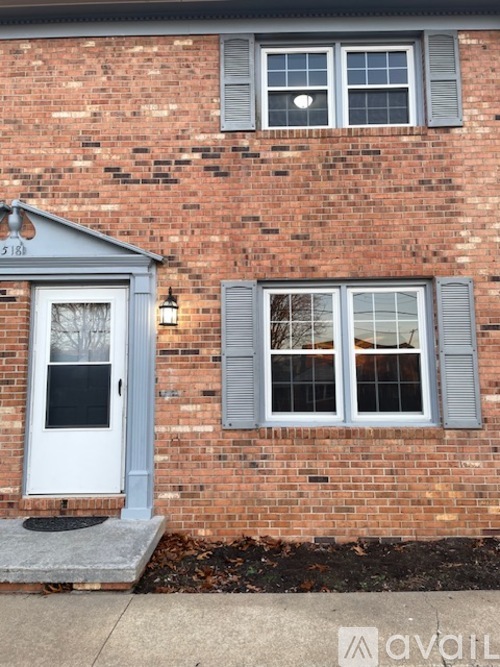 A house with a white door and grey shutters.