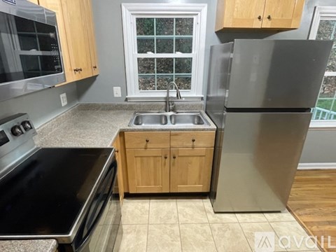 A kitchen with a stainless steel refrigerator, sink, and oven.