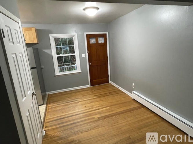A room with a wooden floor and a white door.