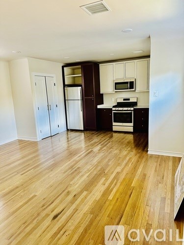 A kitchen with wooden floors and white walls.