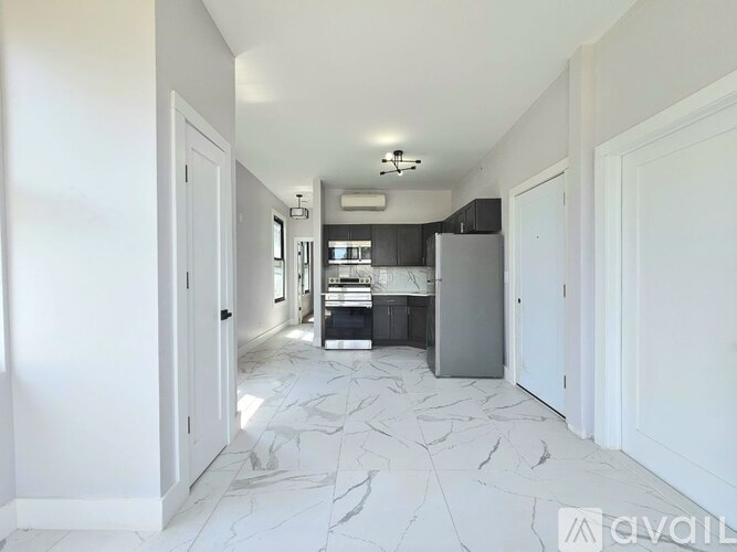 A kitchen with a marble floor and white walls.