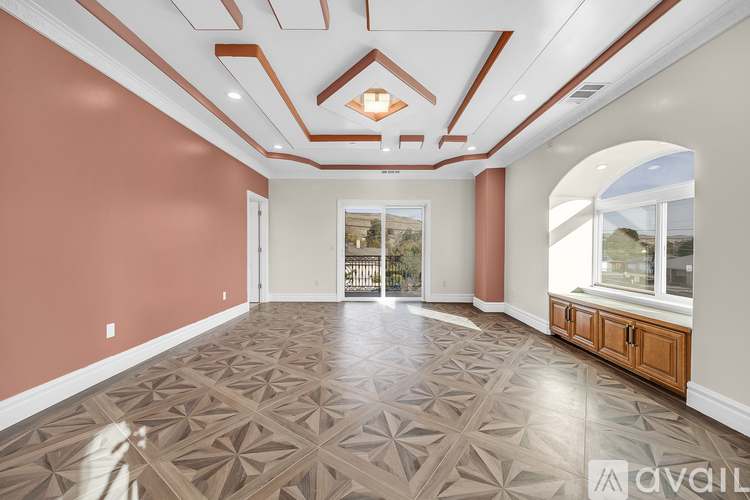 A spacious room with a patterned floor and a skylight.