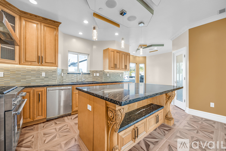 A kitchen with wooden cabinets and a marble countertop.