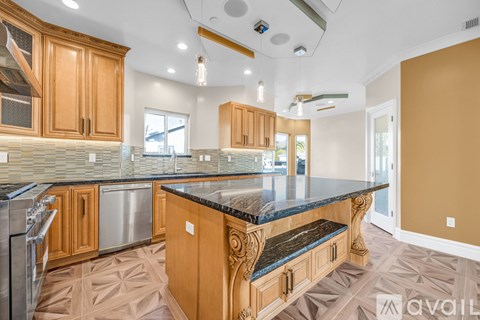 A kitchen with wooden cabinets and a marble countertop.