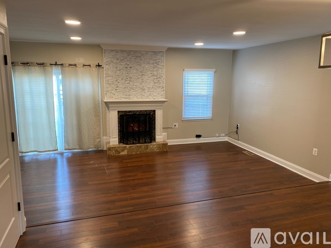 A spacious living room with a fireplace and hardwood floors.