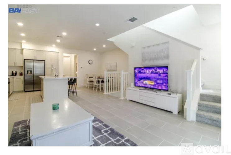 A modern living room with a flat screen TV on a white stand.
