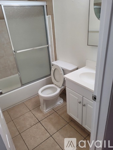 A white toilet sits in a bathroom next to a glass shower door.