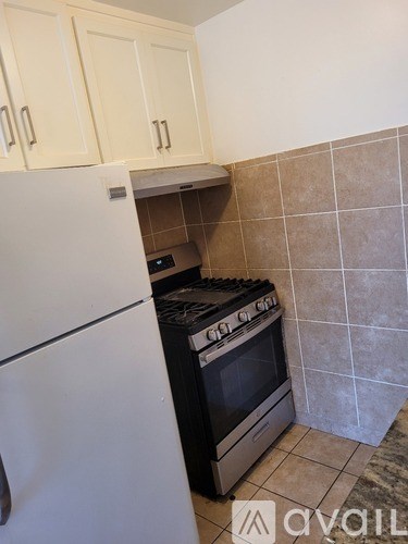 A kitchen with a white refrigerator and a black stove top oven.