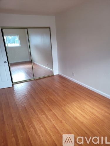 A room with wooden flooring and a sliding door.