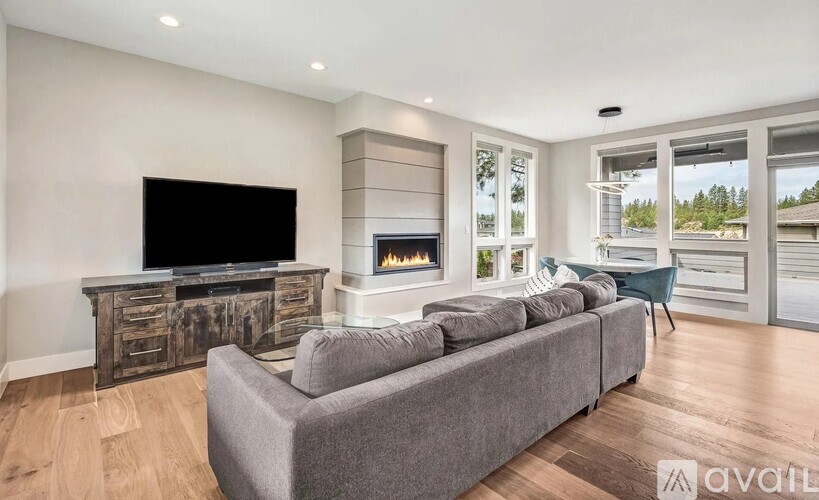 A modern living room with a grey sofa and a wooden cabinet.