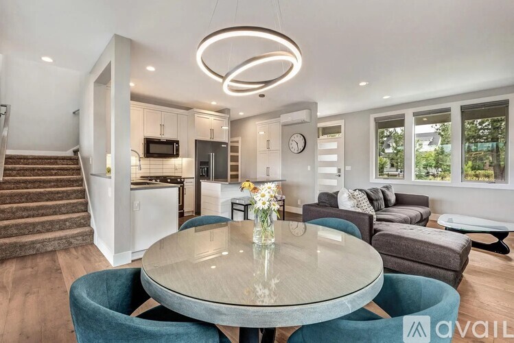 A modern dining room with a glass table and blue chairs.