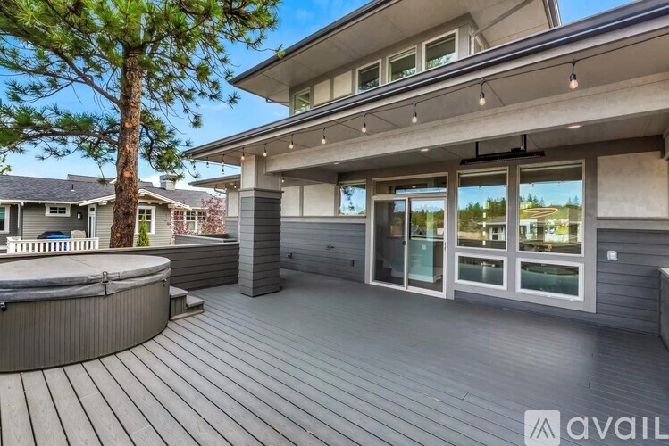 A modern house with a wooden deck and a hot tub.