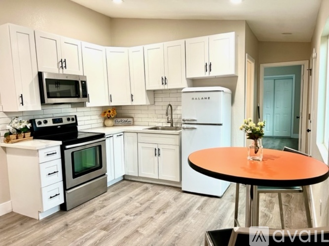 A kitchen with white cabinets and a black stove top oven.