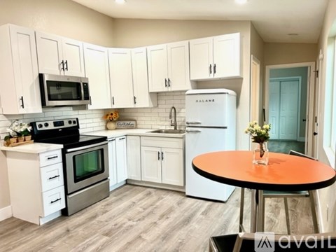 A kitchen with white cabinets and a black stove top oven.