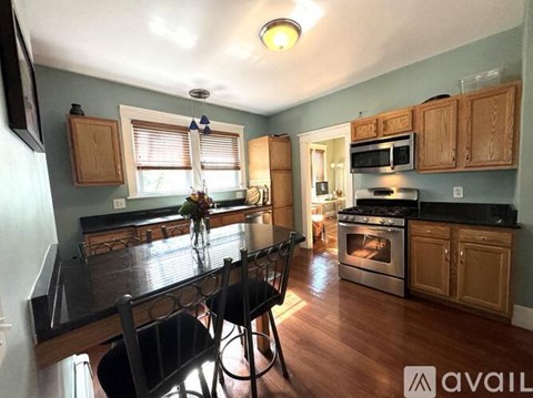 A kitchen with wooden cabinets and a black countertop.
